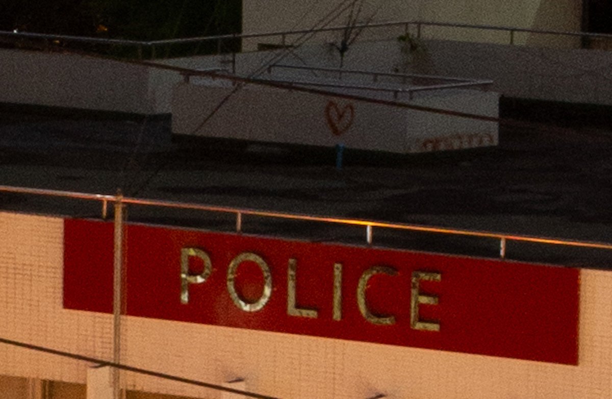 Unedited image of rooftop and police sign in Adobe Lightroom