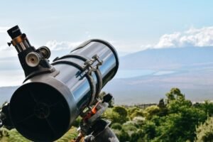 Telescope set up on a hilltop overlooking a cove