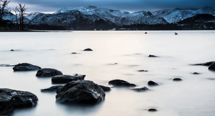 Moody lakeside photo with mountains in the background