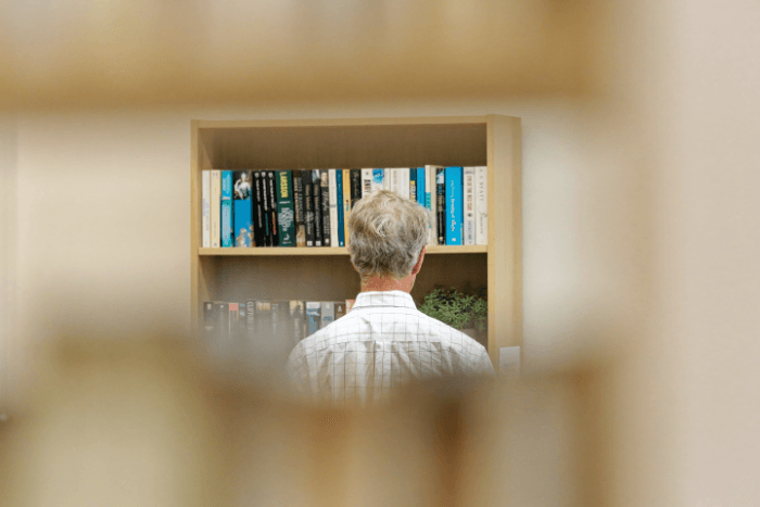 Picture of a man looking at books in a library